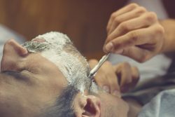 Young,Man,Getting,An,Old-fashioned,Shave,At,The,Barber,Shop.
